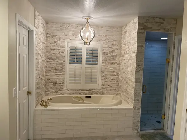 Finished bathroom remodel with tiled tub surround